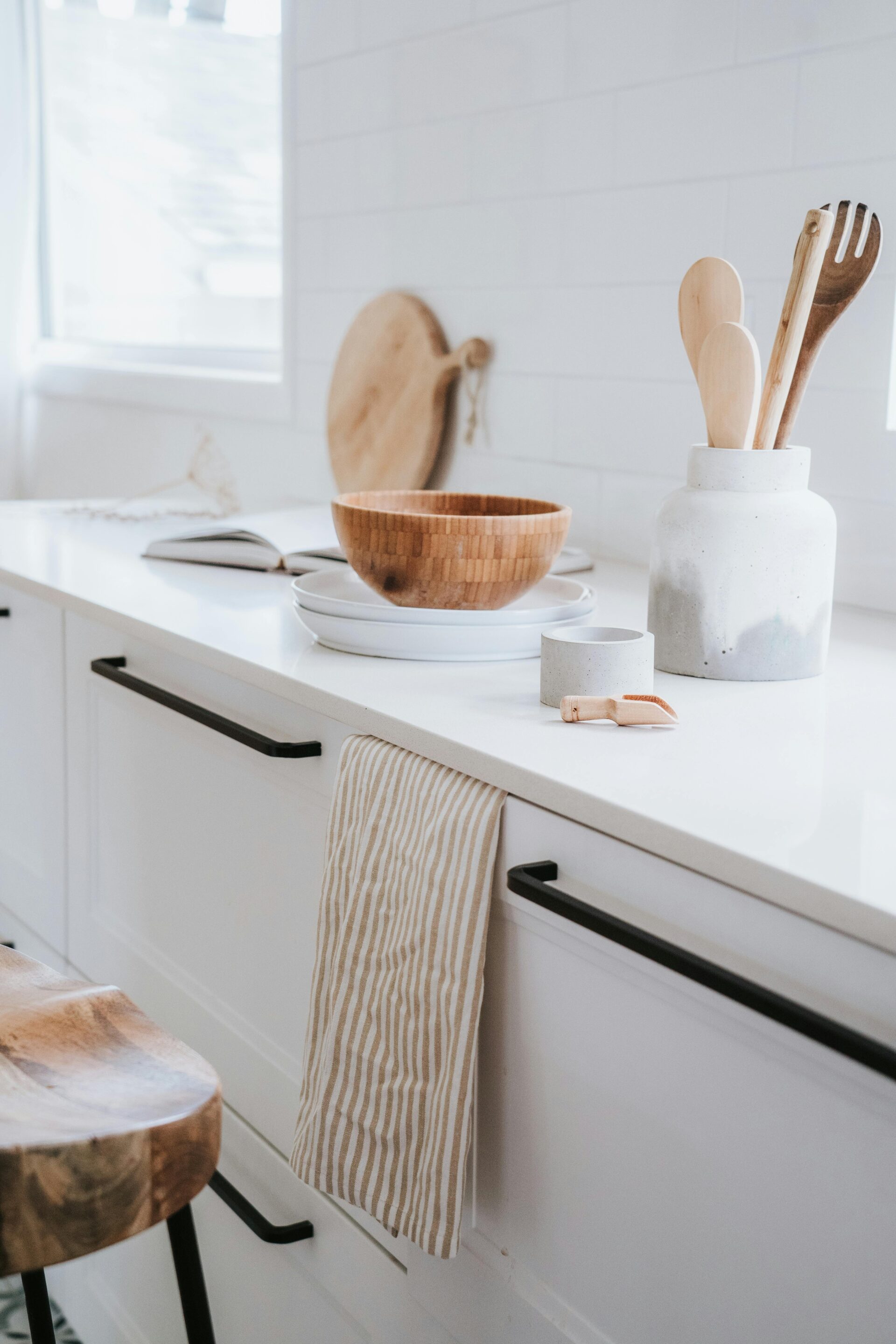 Basic white cabinets with modern, matte black pulls, highlighting contrast when choosing cabinetry hardware.